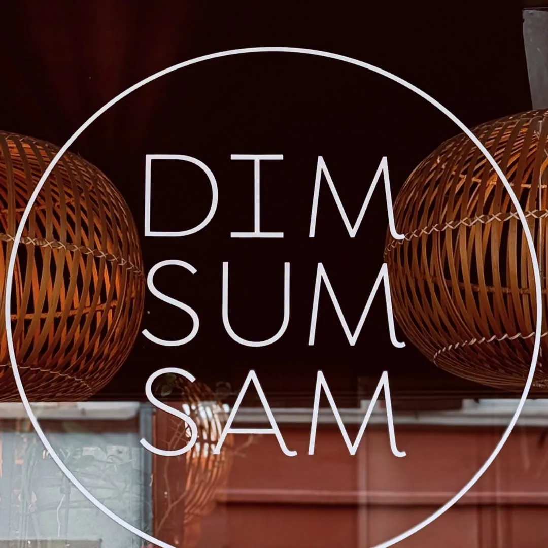 Le logo Dim Sum Sam sur la vitrine, lampes en rotin